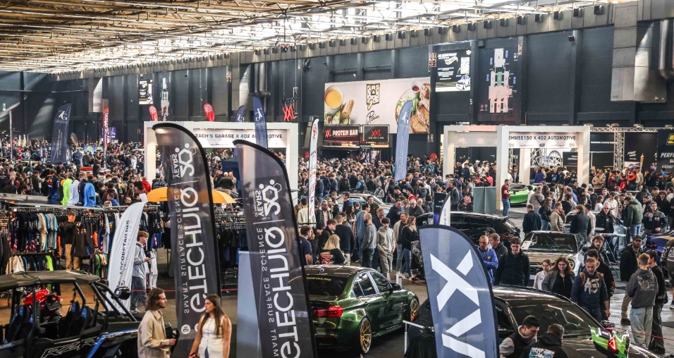 Drukke beursvloer met stands en activaties bij 402 Automotive